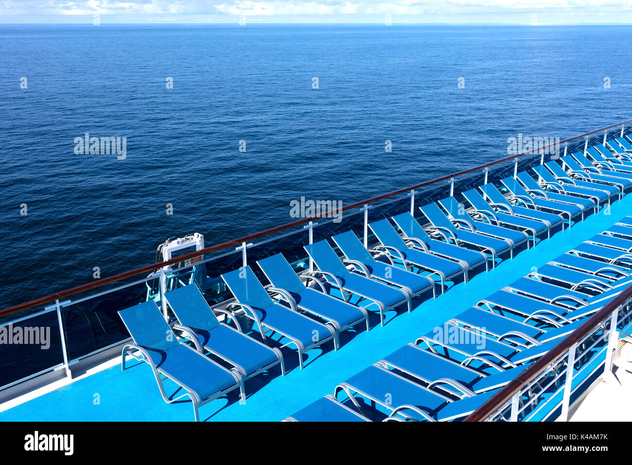blue loungers on the deck of a transatlantic with the ocean background Stock Photo