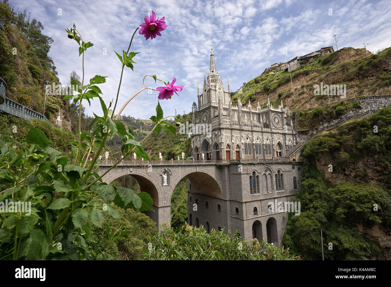 February 23, 2017 Las Lajas, Colombia:  the famous sanctury built on the top of a canyon with blooming flowers in the foreground Stock Photo