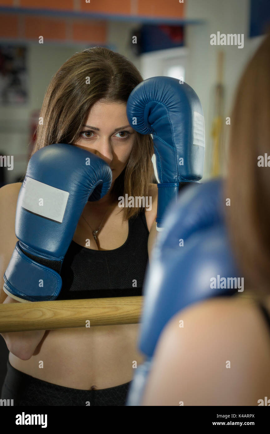 Young Woman Training Boxing And Tries To Protect Her Face With His