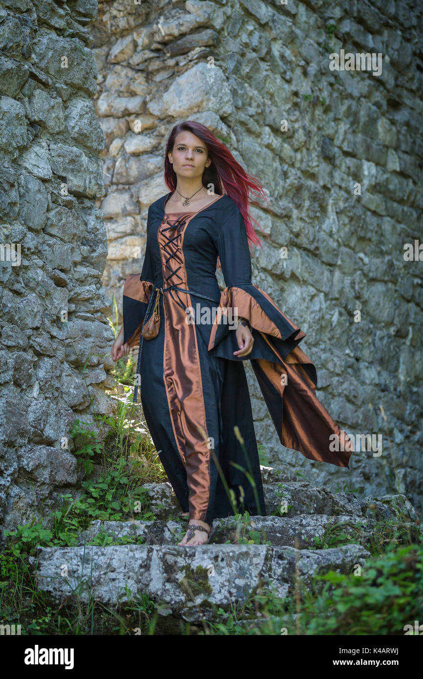 Young RedHaired Woman In Medieval Clothes Rushes Down From The