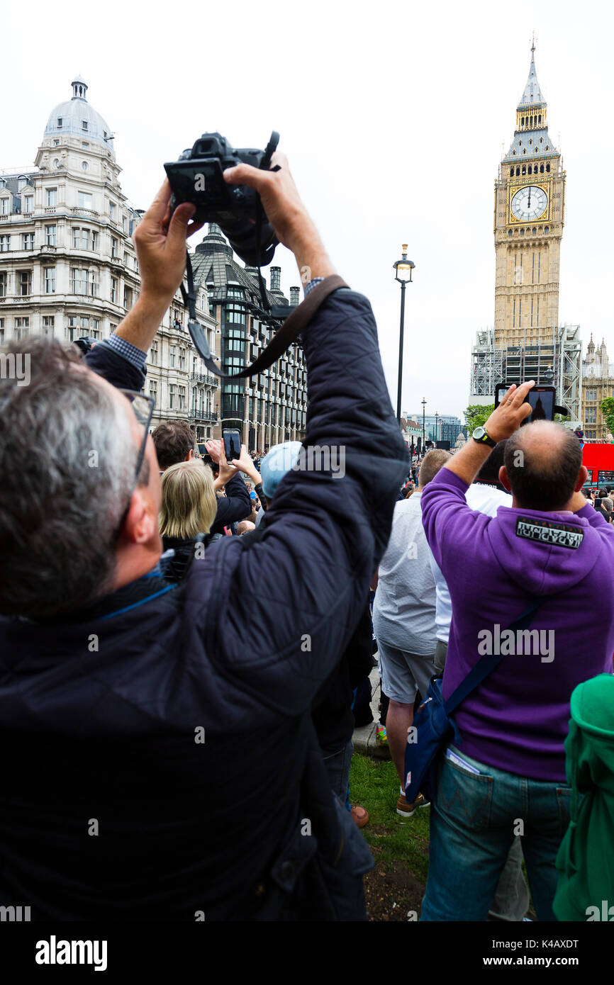 London, UK. A man raises a camera above his head to photograph Big Ben as it sounds its final bongs for four years. Stock Photo