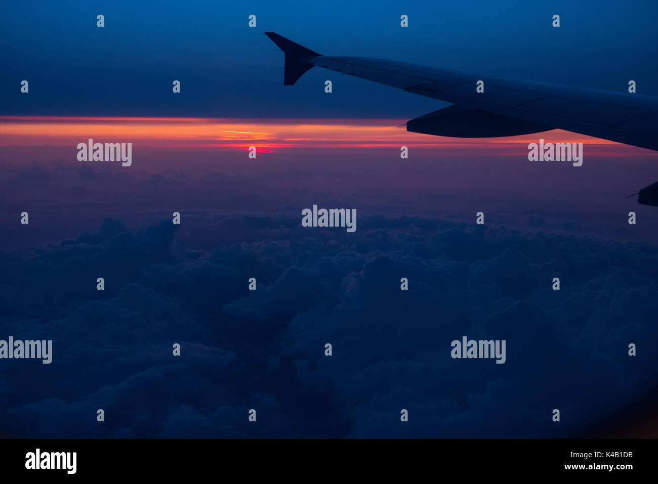 Sunset view from an airplane. Flying over the clouds in colorful sunset ...