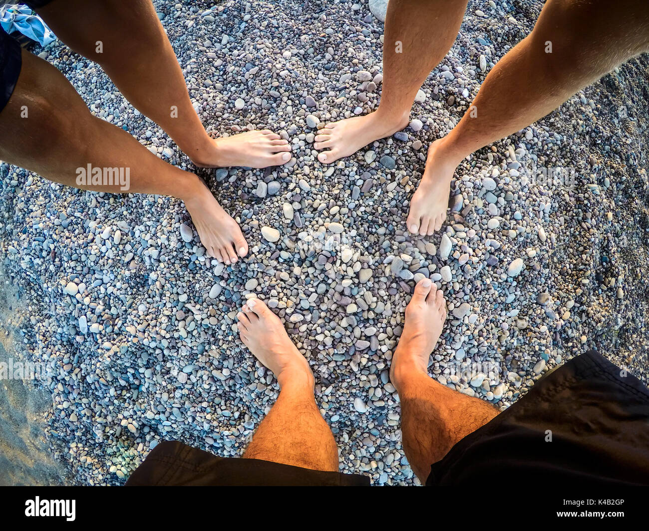 feet of teenagers sons and father on the beach to the sea - summertime - Sicily mediterranean sea Stock Photo