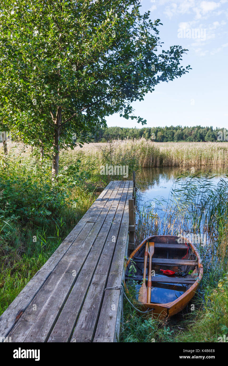 Rowing boat by a jetty in a lake Stock Photo - Alamy