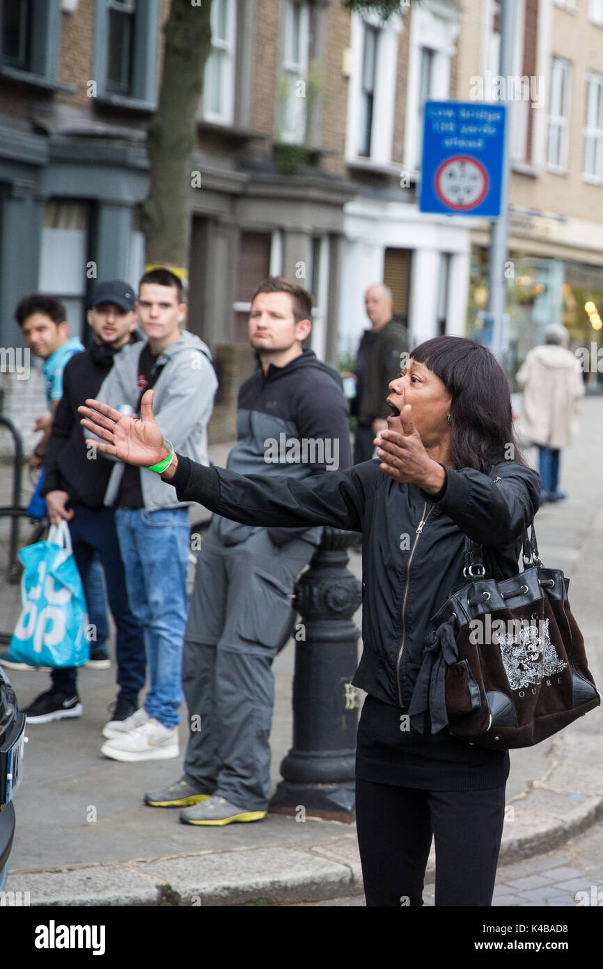 London, UK. 5th Sep, 2017. A woman is shepherded away from the site of the newly established royal foundation Support4Grenfell Community Hub in north Kensington being visited by the Duke of Cambridge and Prince Harry after suggesting that they should visit the 'real volunteers'. Credit: Mark Kerrison/Alamy Live News Stock Photo
