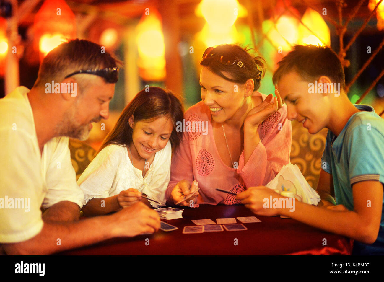 Happy family playing cards Stock Photo - Alamy