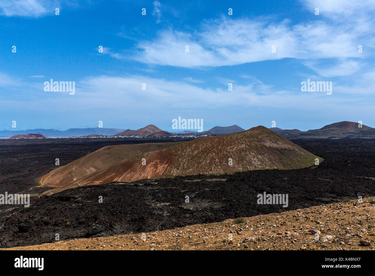 Cold Lava Flow And Volcano Crater West Of Mancha Blanca In Timanfaya National Park, Lanzarote, Canary Islands, Spain Stock Photo