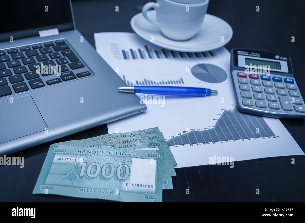 Laptop, coffee cup, pen, calculator, graphs and money Lebanese pound,  finance concept, home economics Stock Photo - Alamy