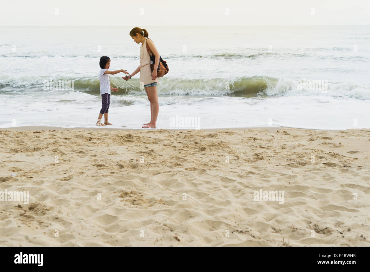 mother and child relationship play beach front Stock Photo
