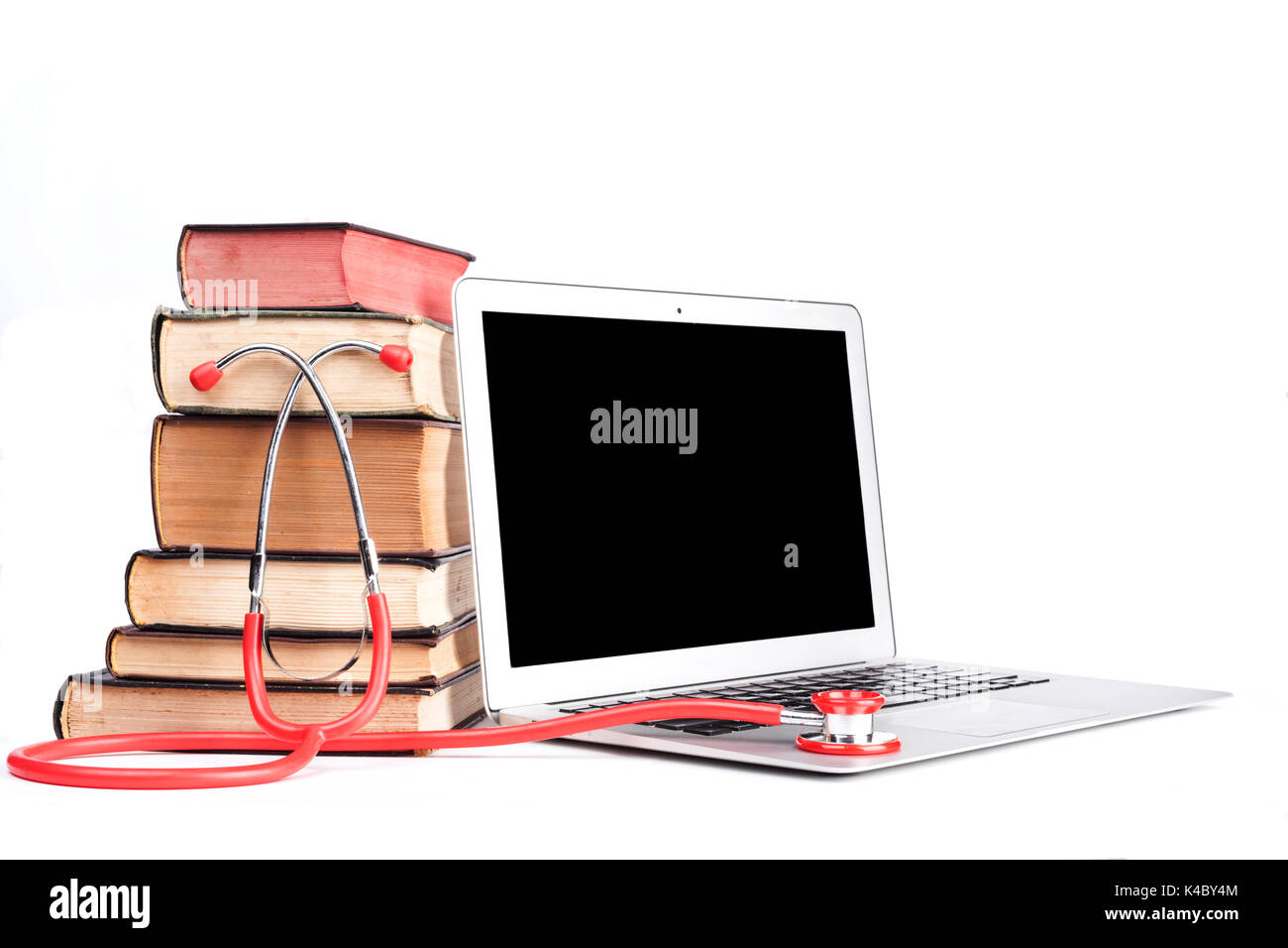 Silver laptop with red stethoscope and old pooks pile isolated on white background Stock Photo