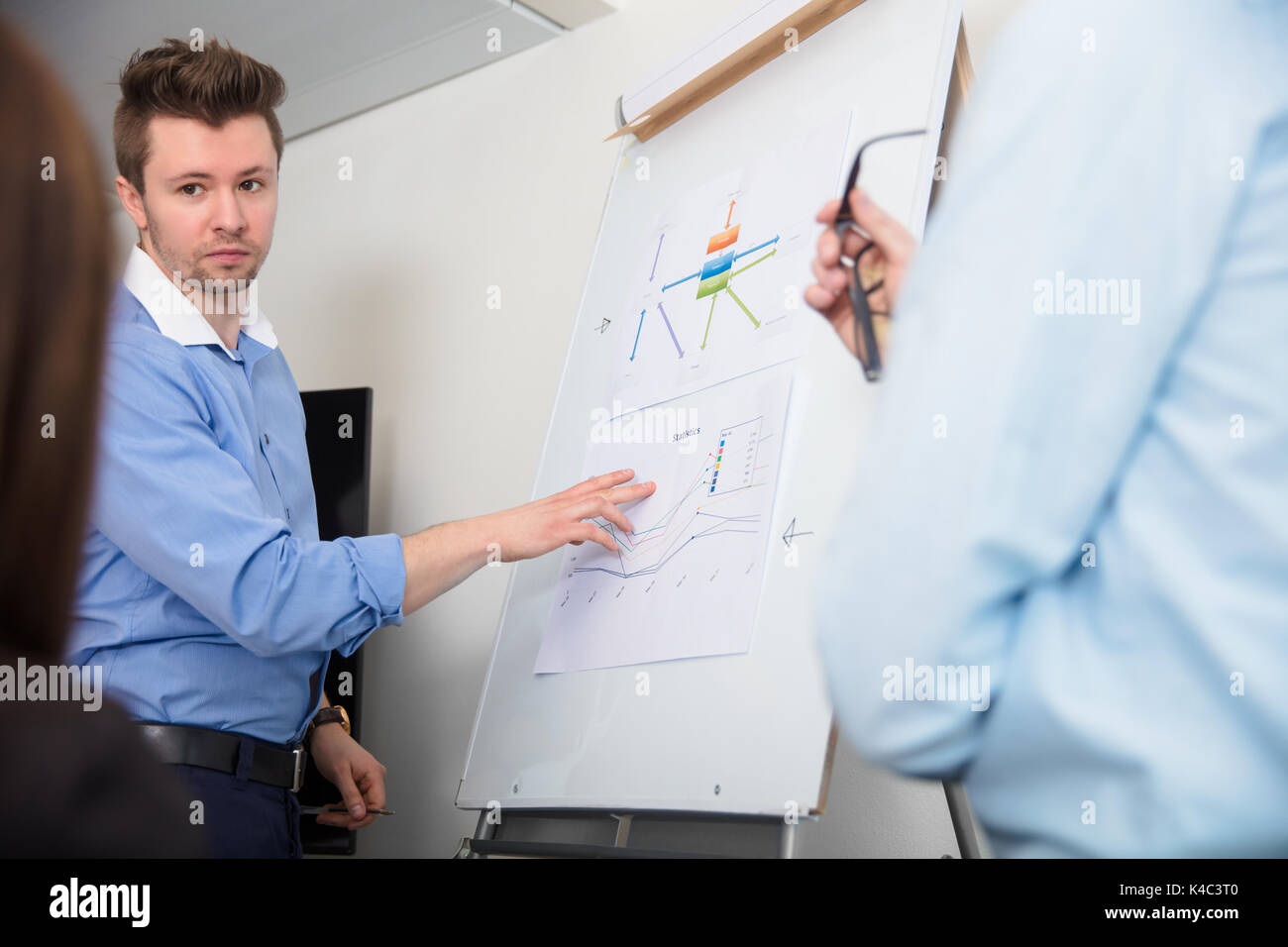 Businessman Touching Document On Flipchart While Giving Presenta Stock Photo