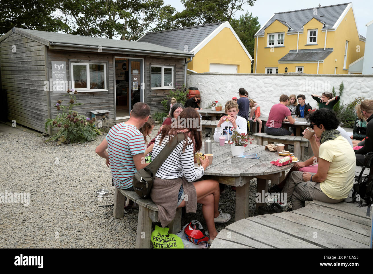 Group of people sitting at table outside Tyf Adventure Centre in St Davids Pembrokeshire Wales UK  KATHY DEWITT Stock Photo
