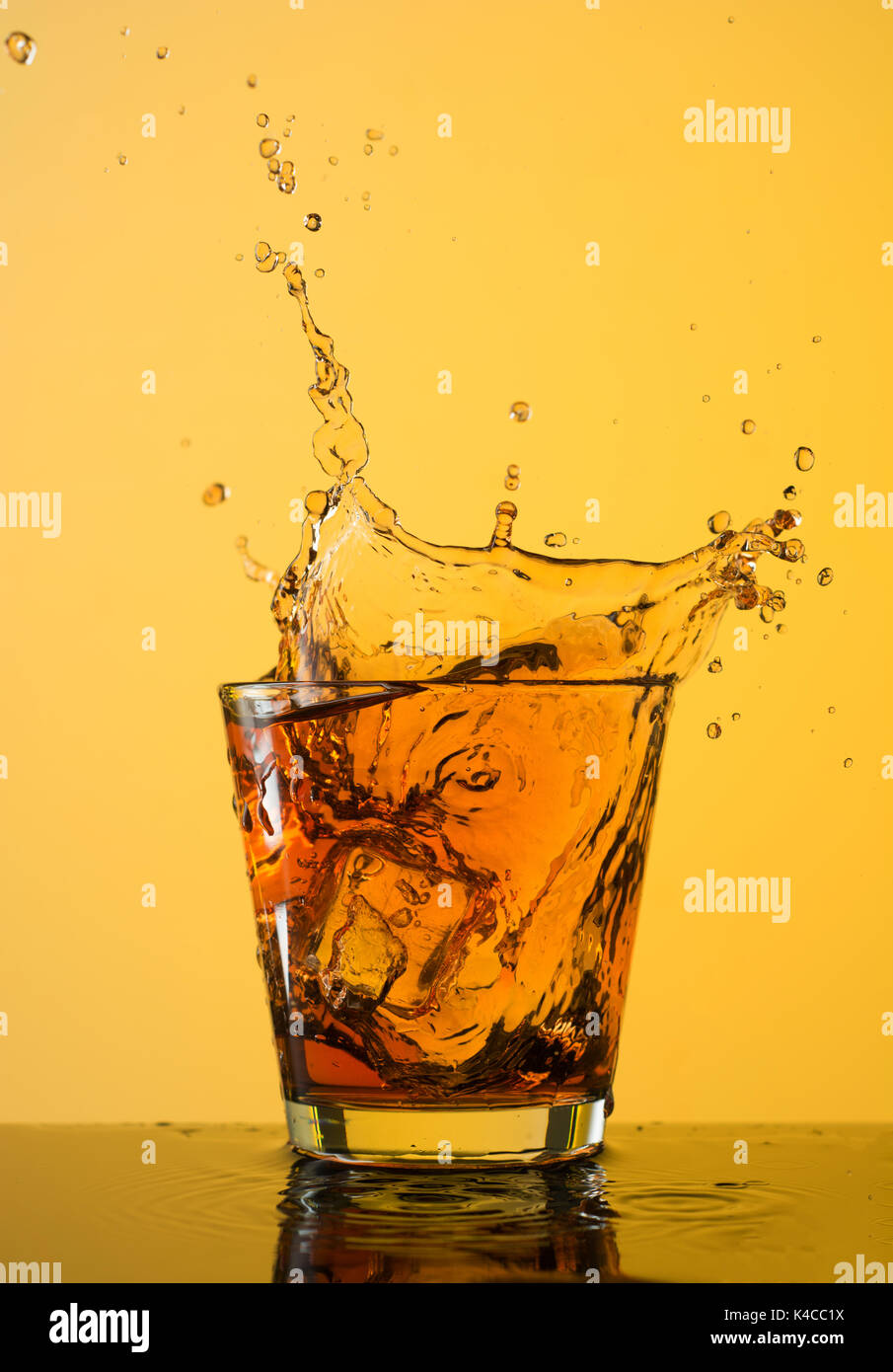Download Whiskey Splash Out Of Glass On Yellow Background Stock Photo Alamy Yellowimages Mockups