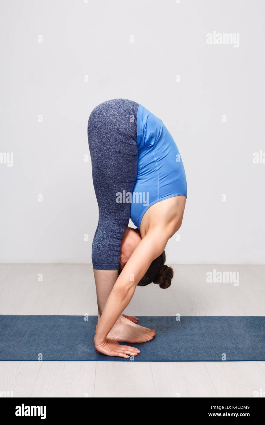 Woman doing yoga asana Uttanasana - standing forward bend  Stock Photo