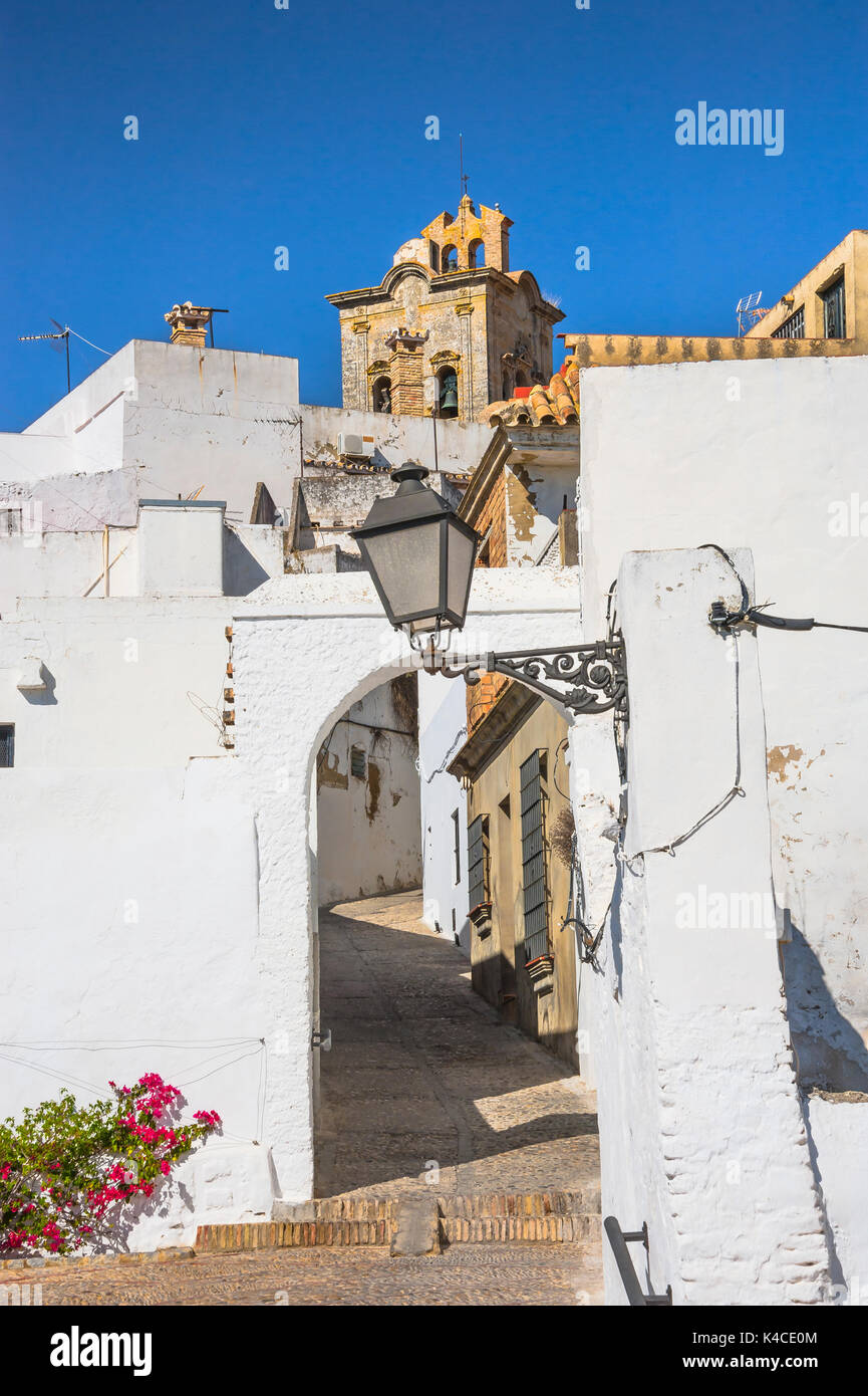 Lane In Arcos De La Frontera And The Bell Tower Of Bas═ Lica De Santa Mar═ A, White Towns Of Andalusia, Province Of Cêdiz, Spain Stock Photo