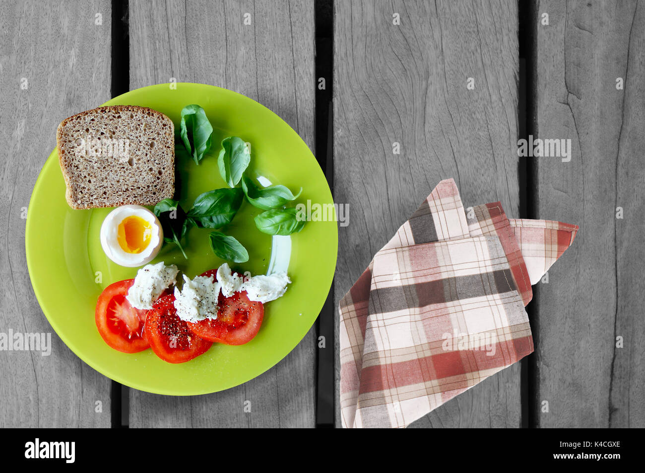 Breakfast plate, tomato, cheese, bread, eggs on wooden table Stock Photo