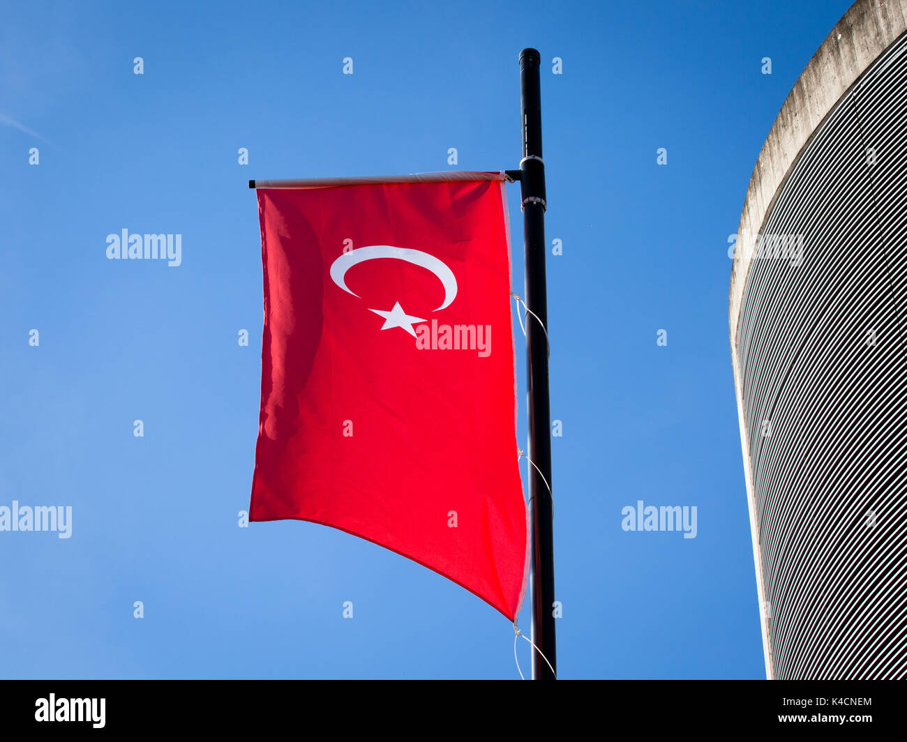 Turkish Flag Next To Building Against Blue Sky Stock Photo