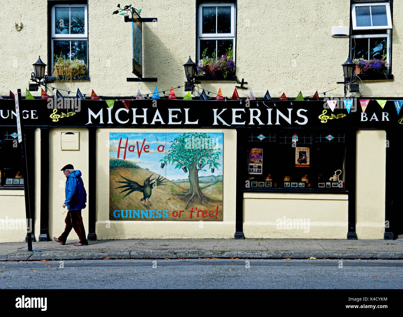 Senior man walking past Michael Kerins Bar, Ennis, County Clare
