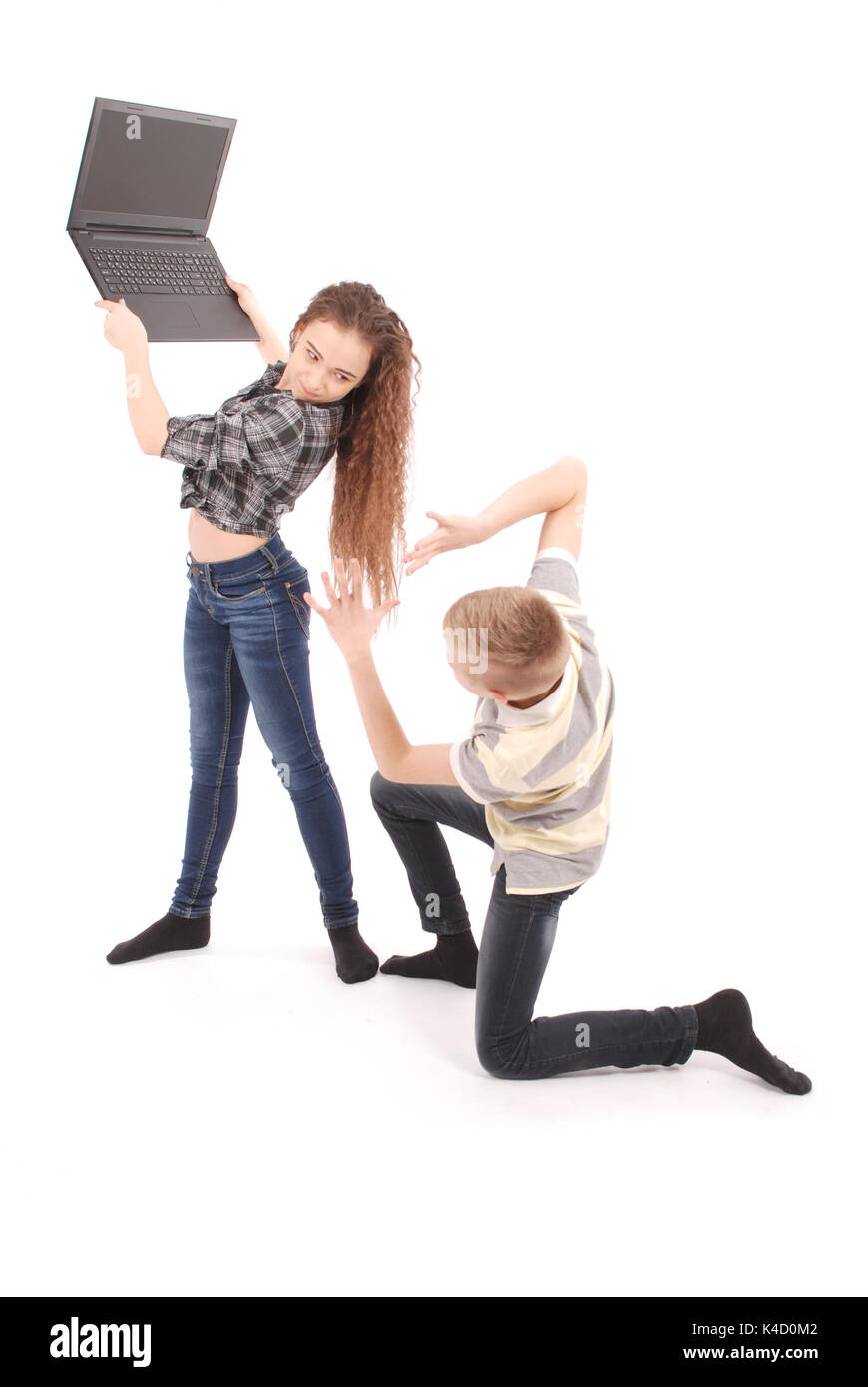 Boy and girl fighting over a laptop, isolated on white Stock Photo