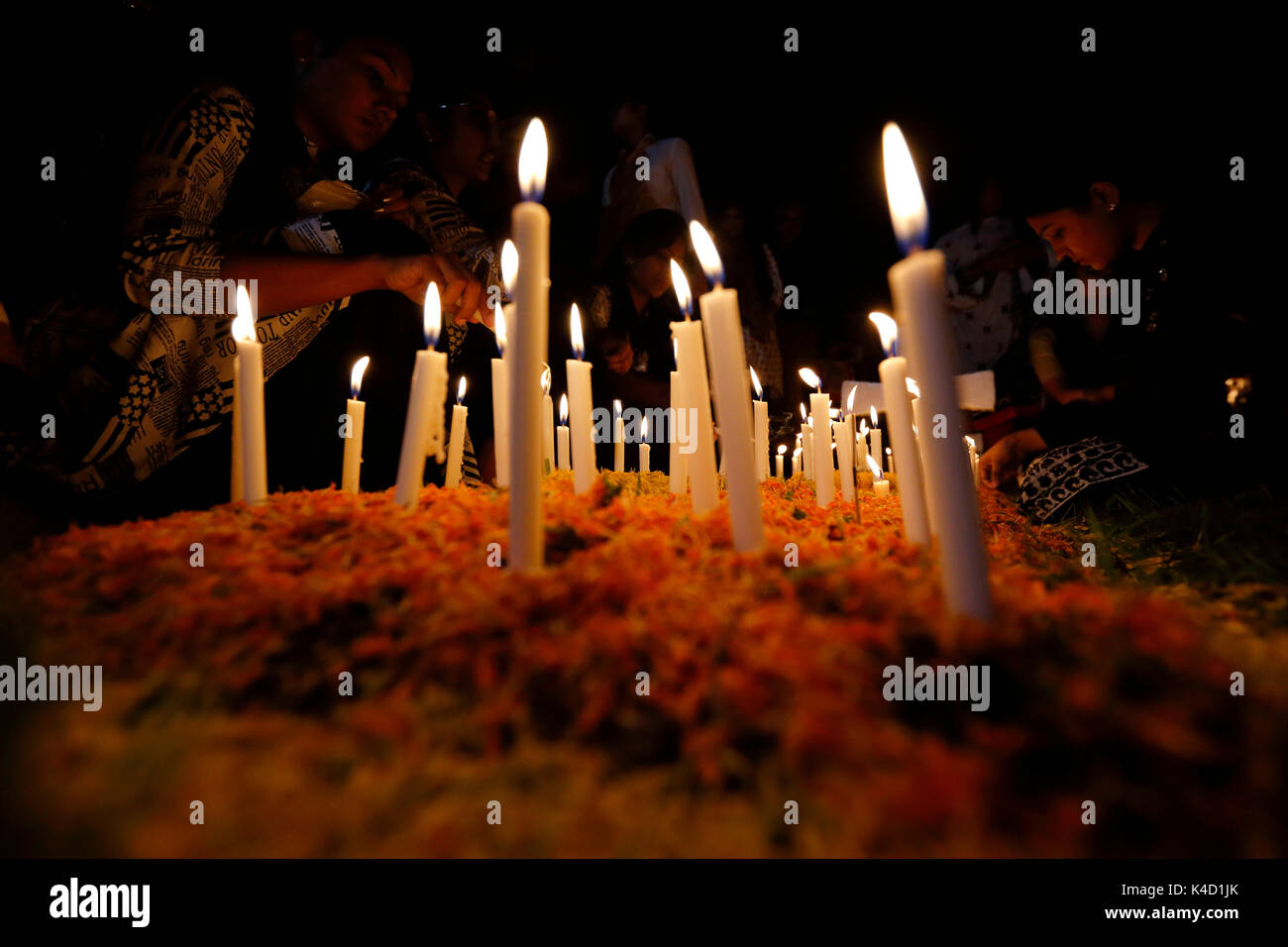 Family members light candles and put them on the graves of their loved