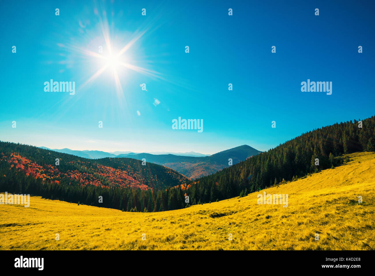 Orange mountains and sun in blue sky Stock Photo