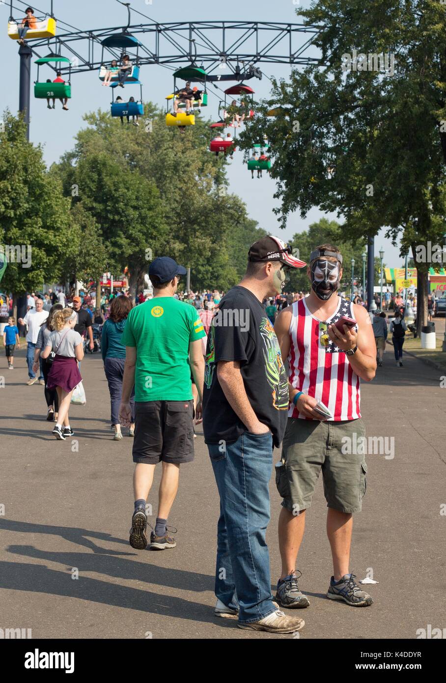 Two men in face paint stand out in a crowd, at the Minnesota State Fair in St. Paul, MN, USA. Stock Photo