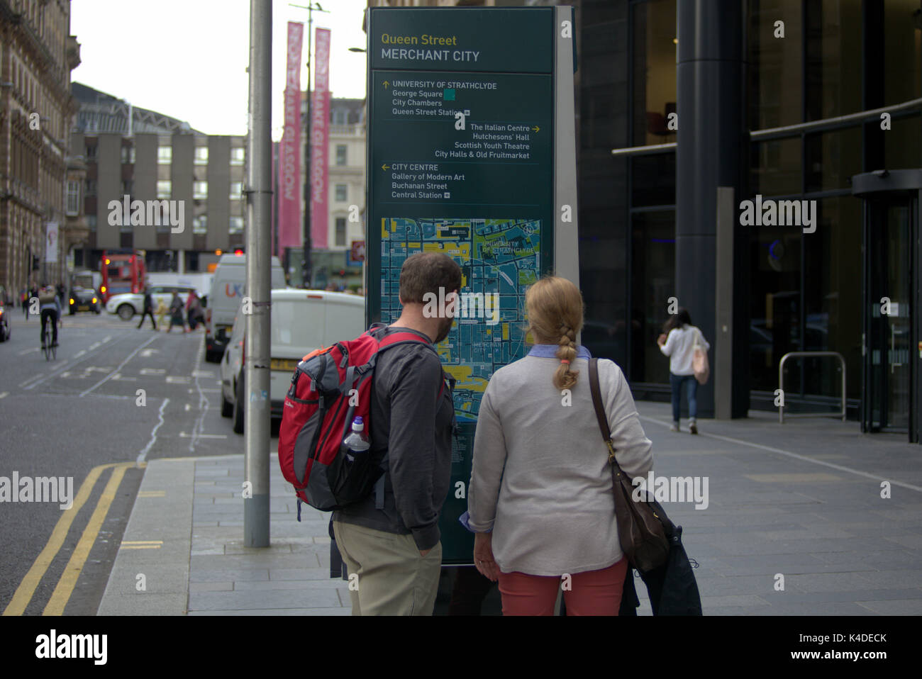 Glasgow street scene tourists consult street map on queen street Stock Photo