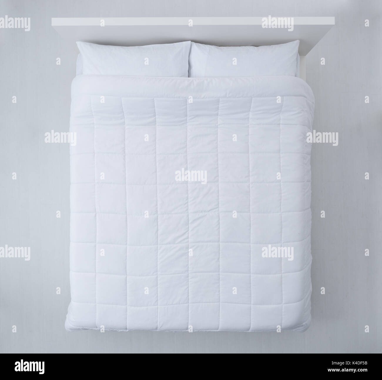 Elegant bed with soft white duvet, bedding and pillows, top view Stock