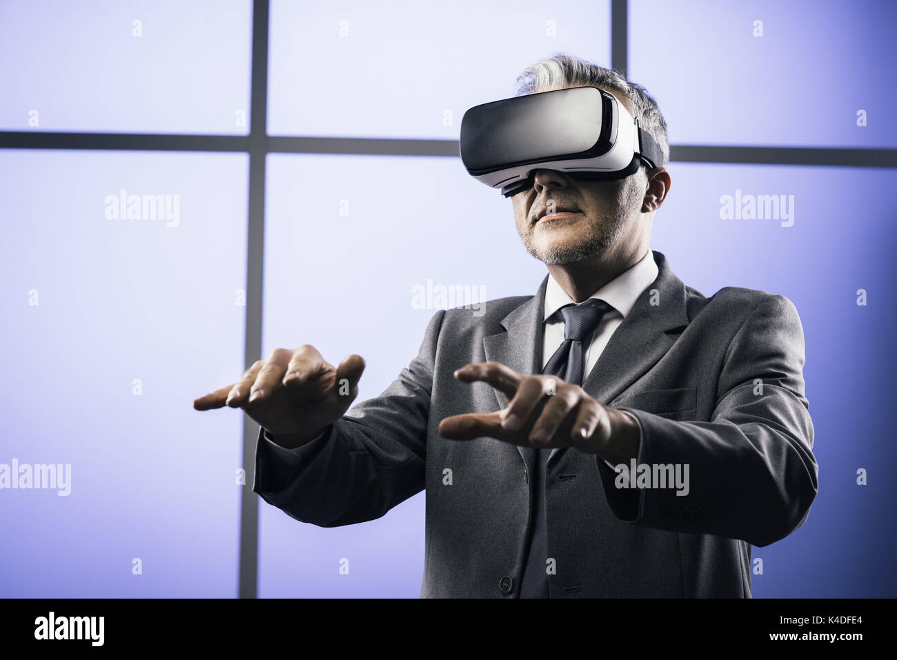 Confident businessman wearing a VR headset and typing with a virtual