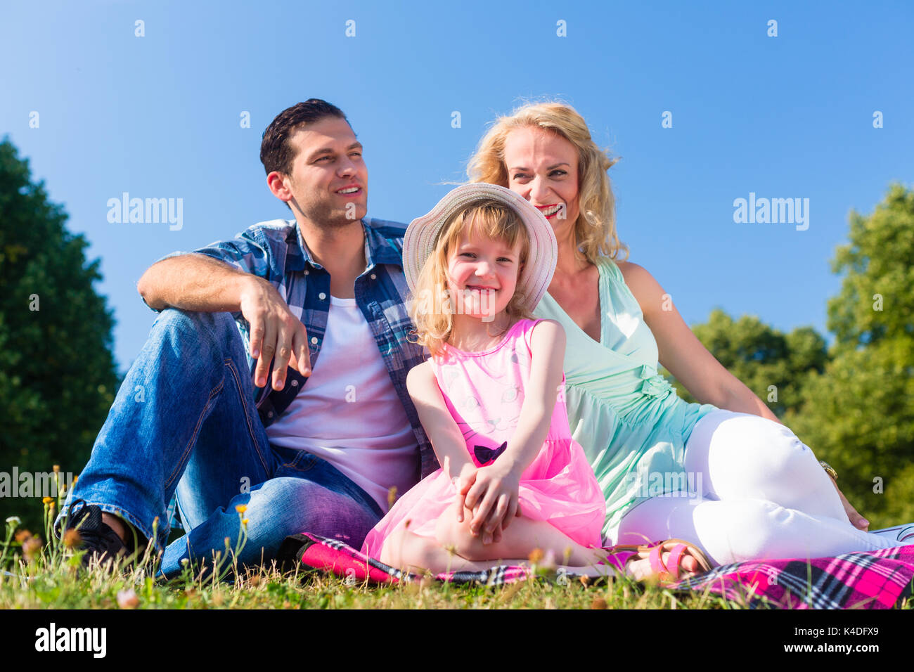 Family photo with father, mother and daughter in meadow Stock Photo