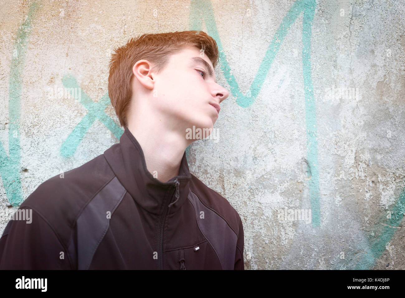 portrait of a young man leaning against a wall Stock Photo - Alamy