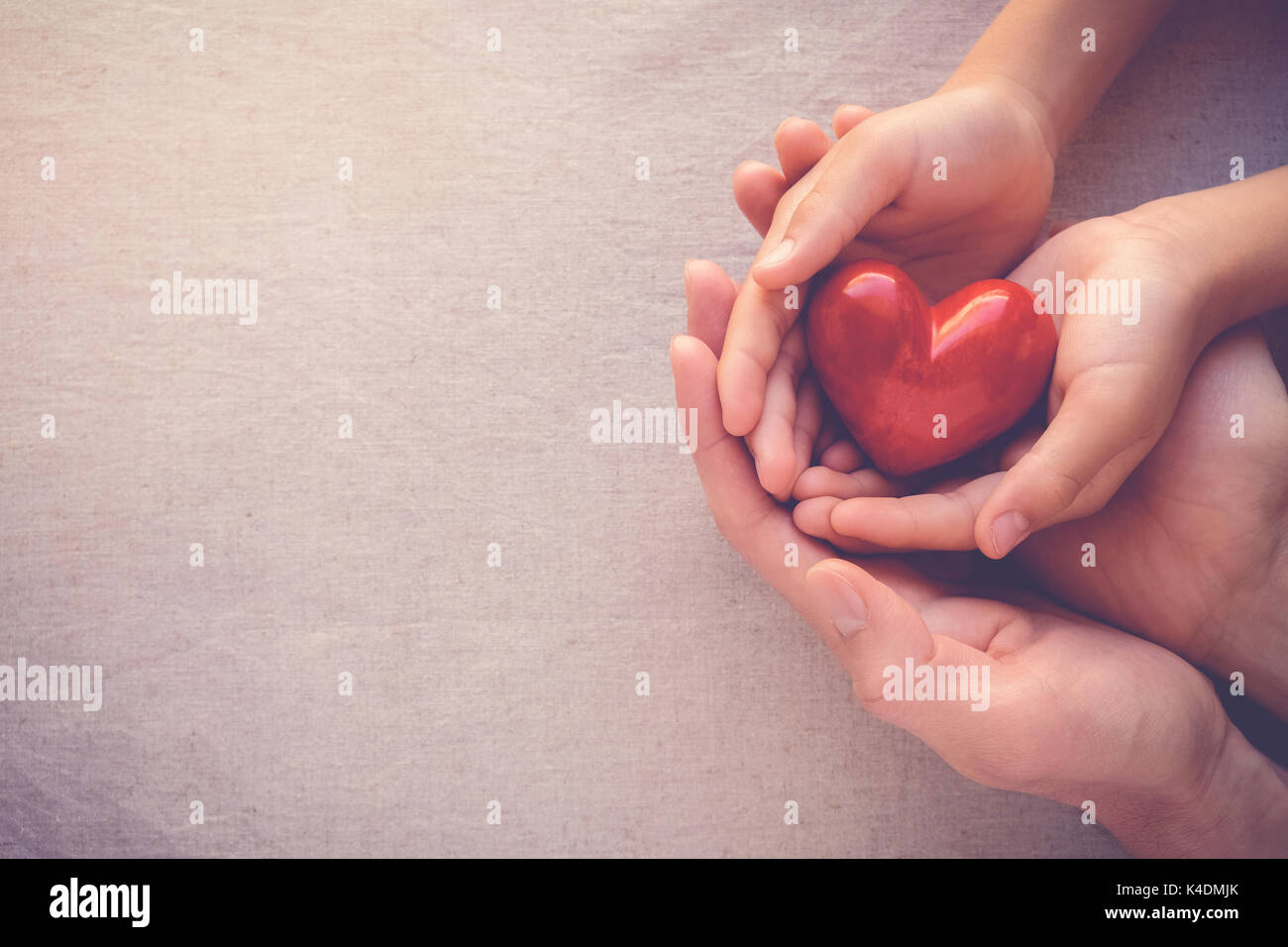 adult and child hands holiding red heart, health care love and family ...