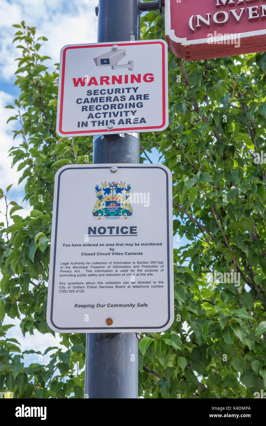Signs warning the public that the area is being monitored by video surveillance cameras. Stock Photo