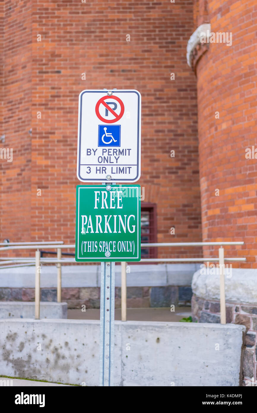 Sign identifying a disabled persons parking space and another indicating that there is no charge to park. Stock Photo