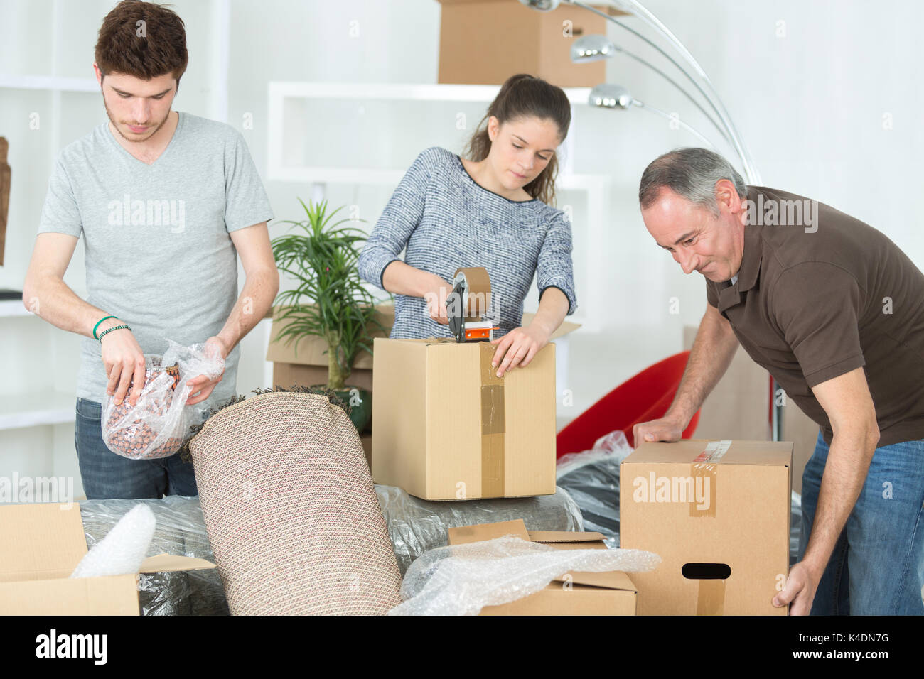 Unpacking Video family unpacking cardboard boxes at new home Stock Photo - Alamy
