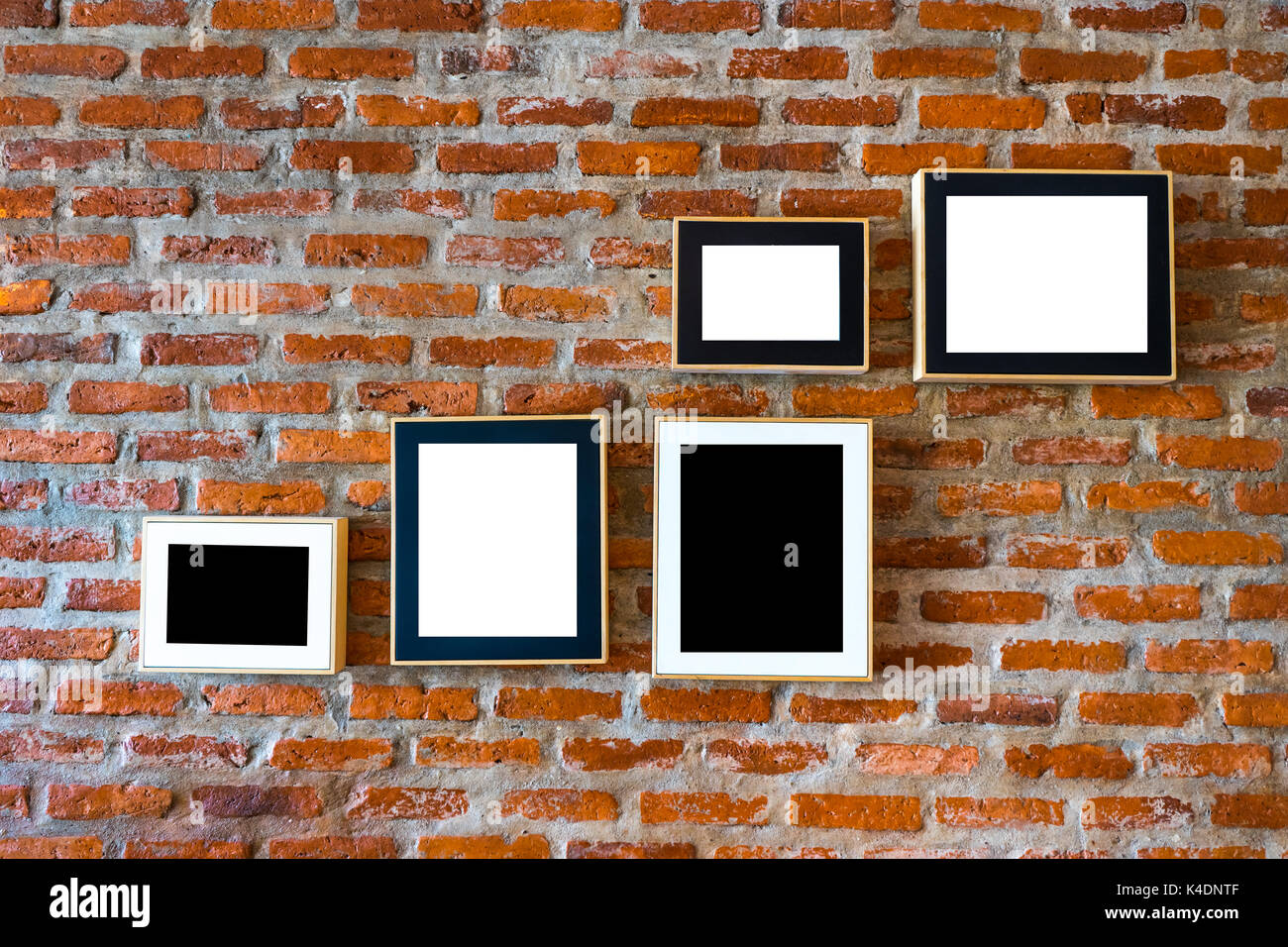 Brick wall decorated with photo frames left blank in black and white