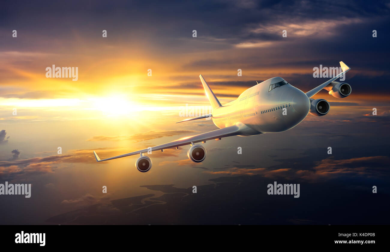 Airplane flying above clouds during sunset Stock Photo