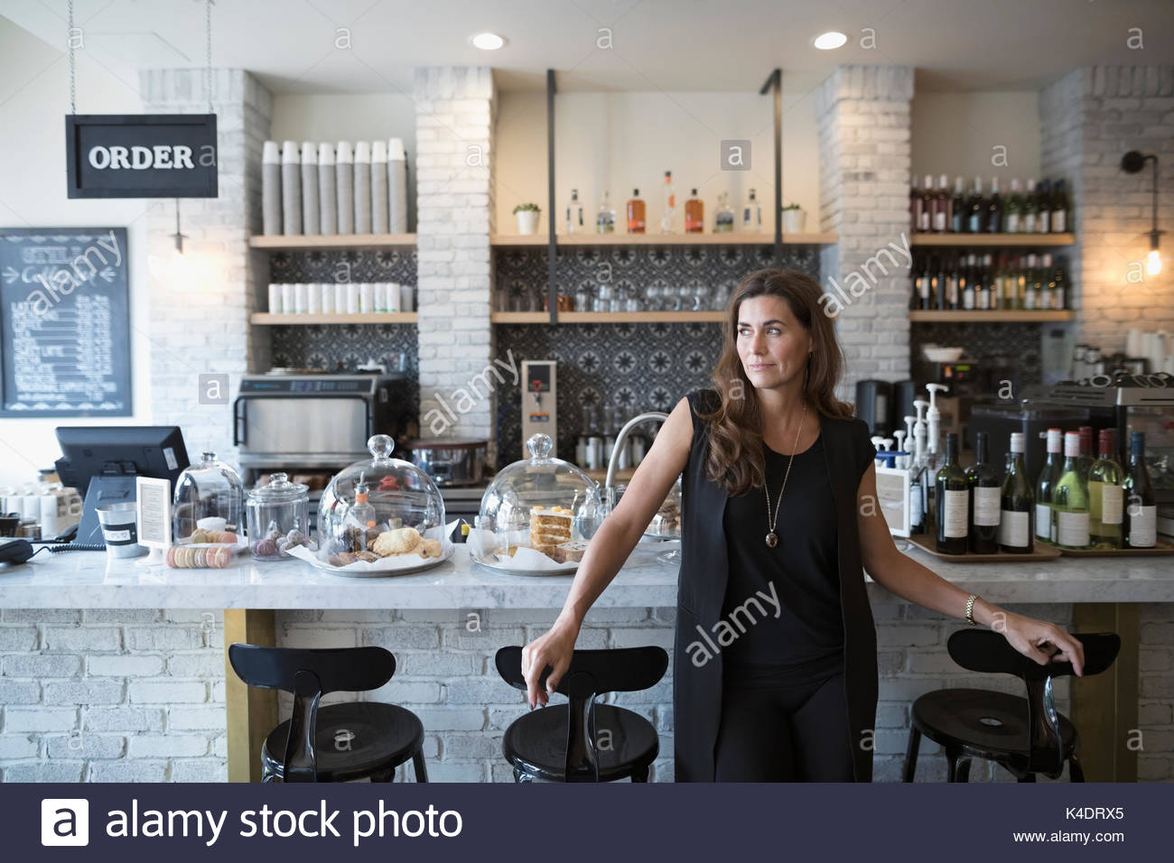 Pensive female cafe owner looking away Stock Photo