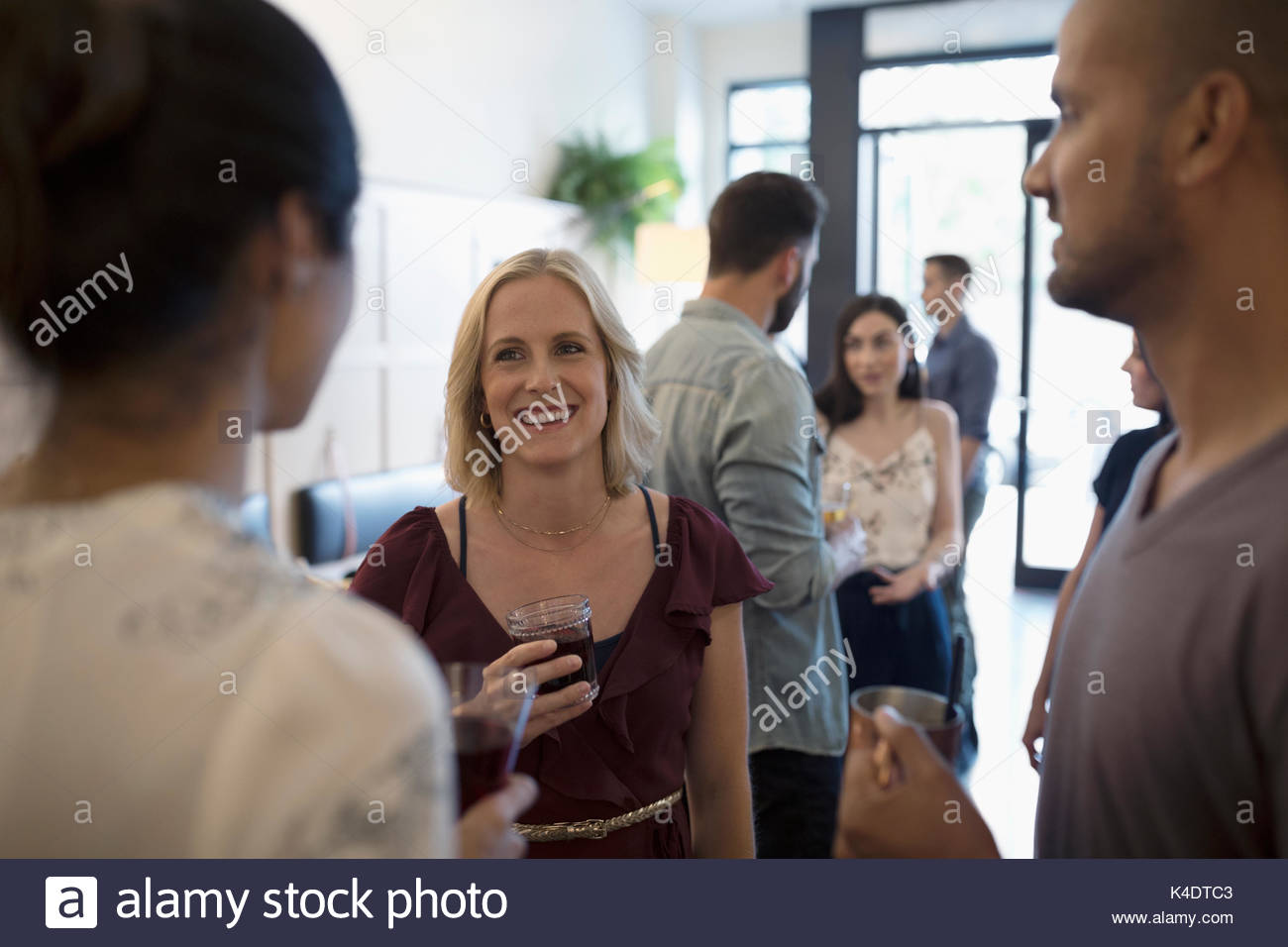 Friends talking and drinking wine, socializing in bar Stock Photo