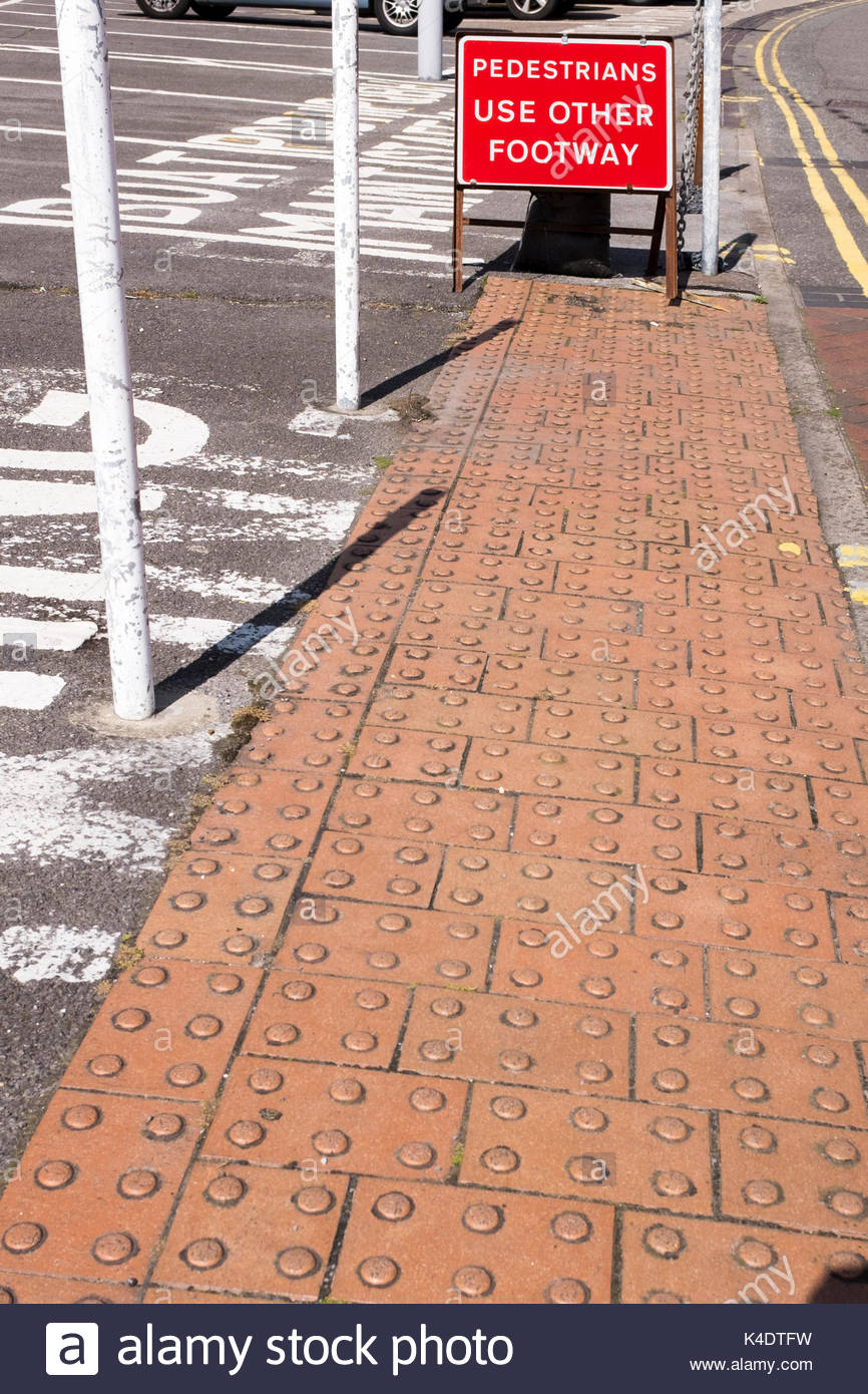 Tactile paving to assist those with visual impairment by road crossing point and Pedestrians Use Other Footway sign, Poole, Dorset, England, UK Stock Photo