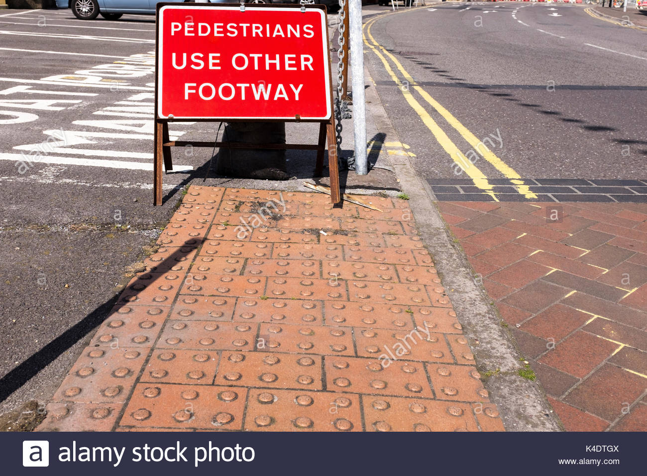 Tactile paving to assist those with visual impairment by road crossing point and Pedestrians Use Other Footway sign, Poole, Dorset, England, UK Stock Photo