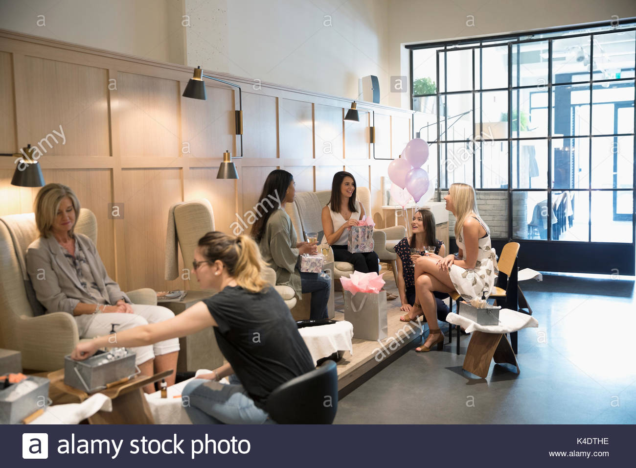 Bride-to-be and bridesmaid friends celebrating bridal shower in nail salon Stock Photo