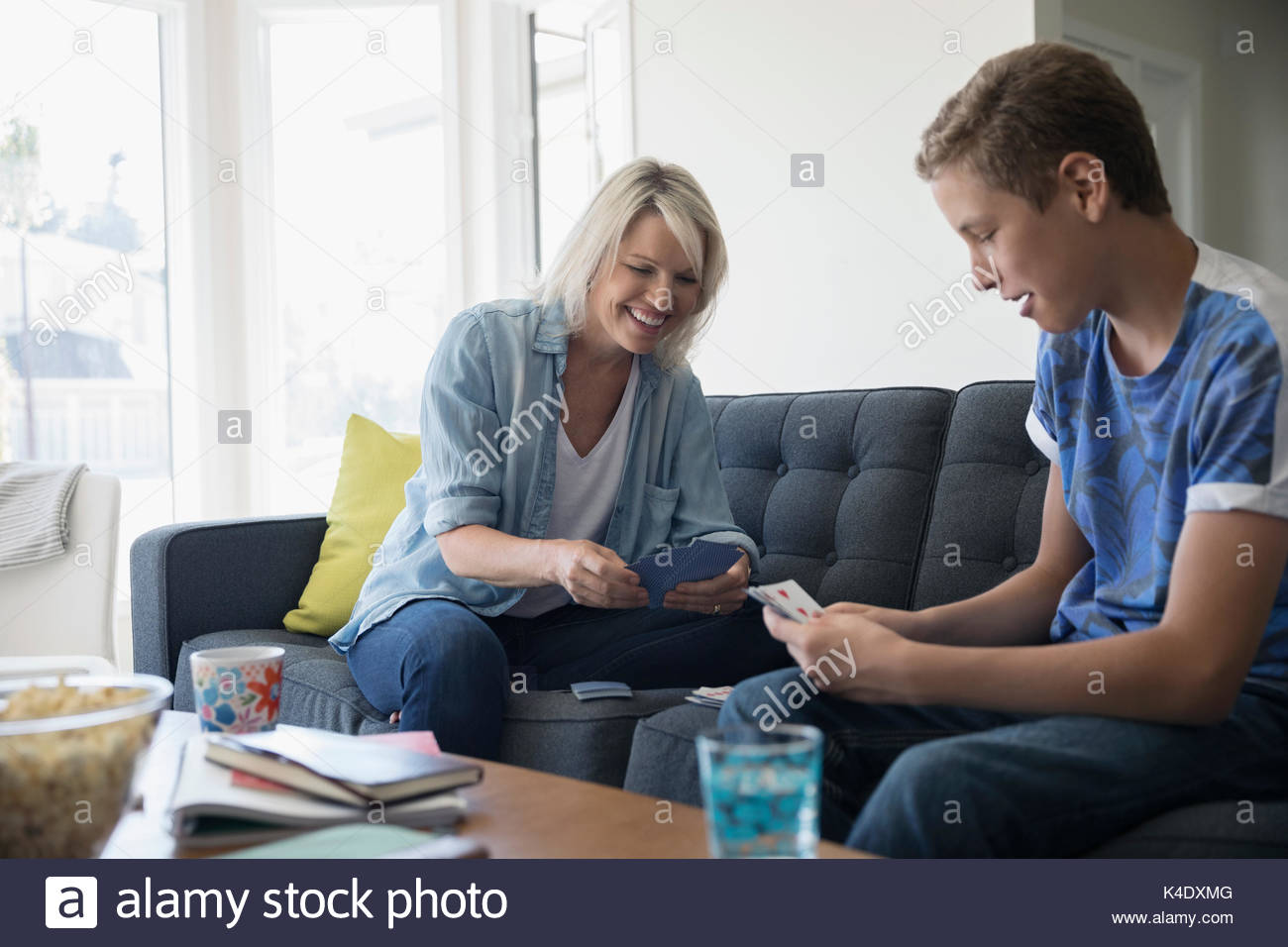 Mother and pre-adolescent son playing cards in living room Stock Photo