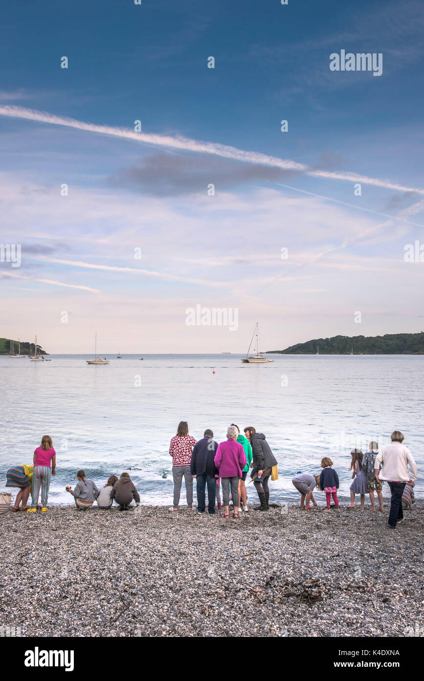 Trebah Garden Beach - adults and children standing on the shoreline of the beach at Trebah Garden in Cornwall. Stock Photo