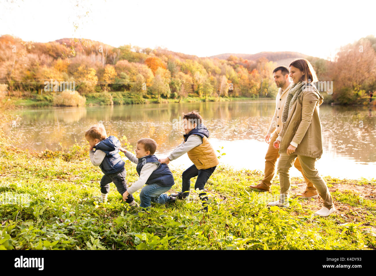 Beautiful young family on a walk in autumn forest Stock Photo - Alamy