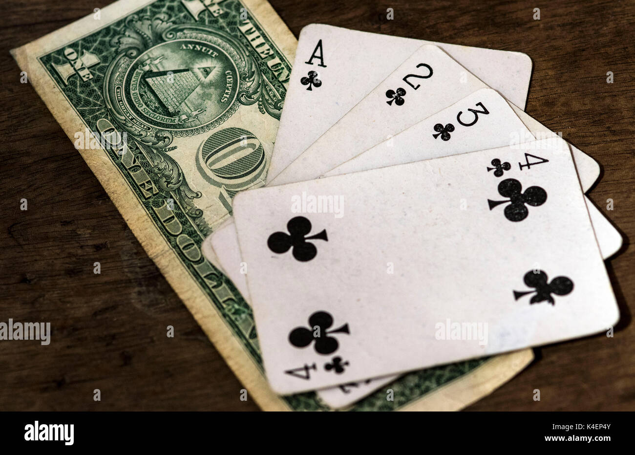 US money one dollar bill and white playing cards, face up, on top of a wooden surface, money, gambling and winning concept idea Stock Photo
