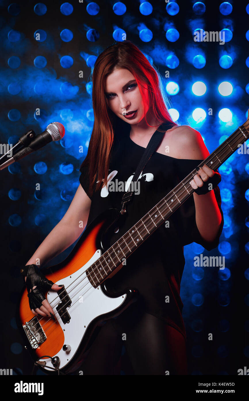 Beautiful young girl performs songs on stage in rock style Stock Photo