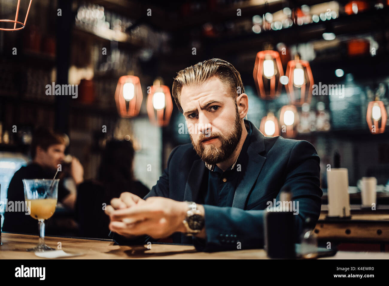 49/5000 bearded man in a suit with a telephone drinks something Stock Photo
