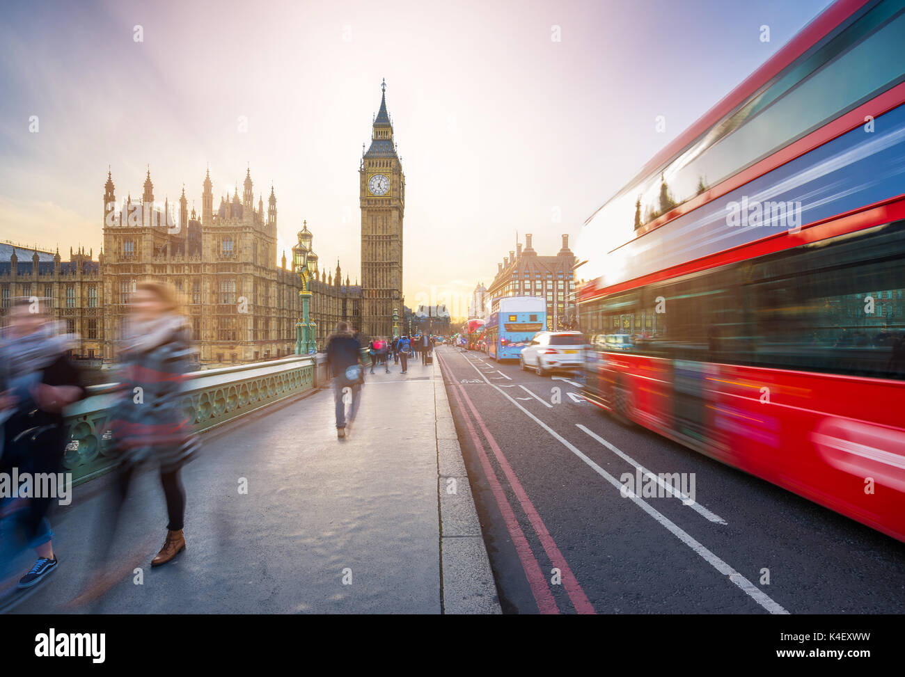 London, England - The iconic Big Ben and the Houses of Parliament with famous red double-decker bus and tourists on the move on Westminster bridge at  Stock Photo