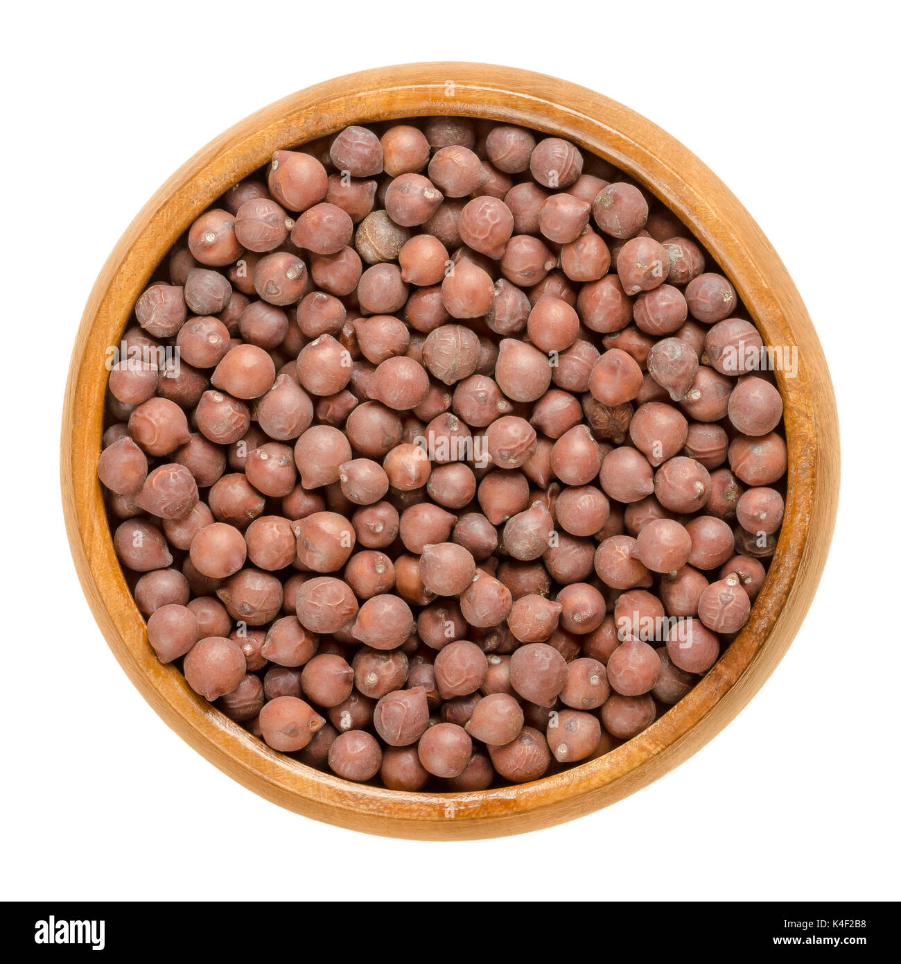 Desi chickpeas in wooden bowl. Dried brown seeds of Cicer arietinum, a legume. Also called Bengal gram, garbanzo bean or Egyptian pea. Photo Stock Photo